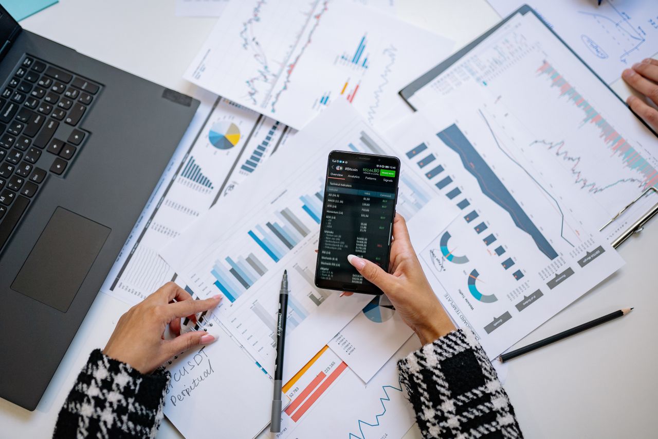 An overhead view of charts and a smartphone in an office, highlighting data analytics.